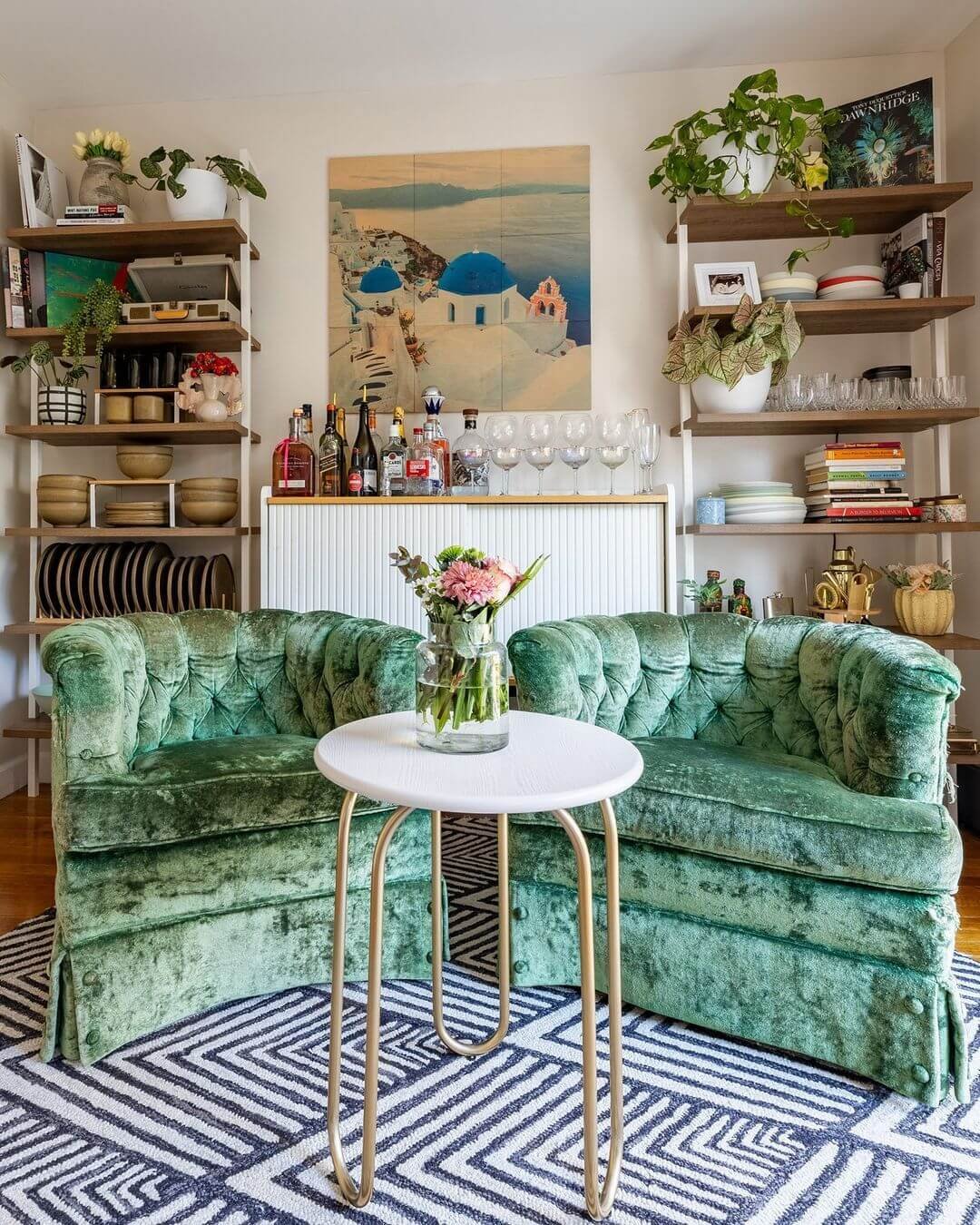 Inviting emerald sofas and eclectic decor create a cozy haven
